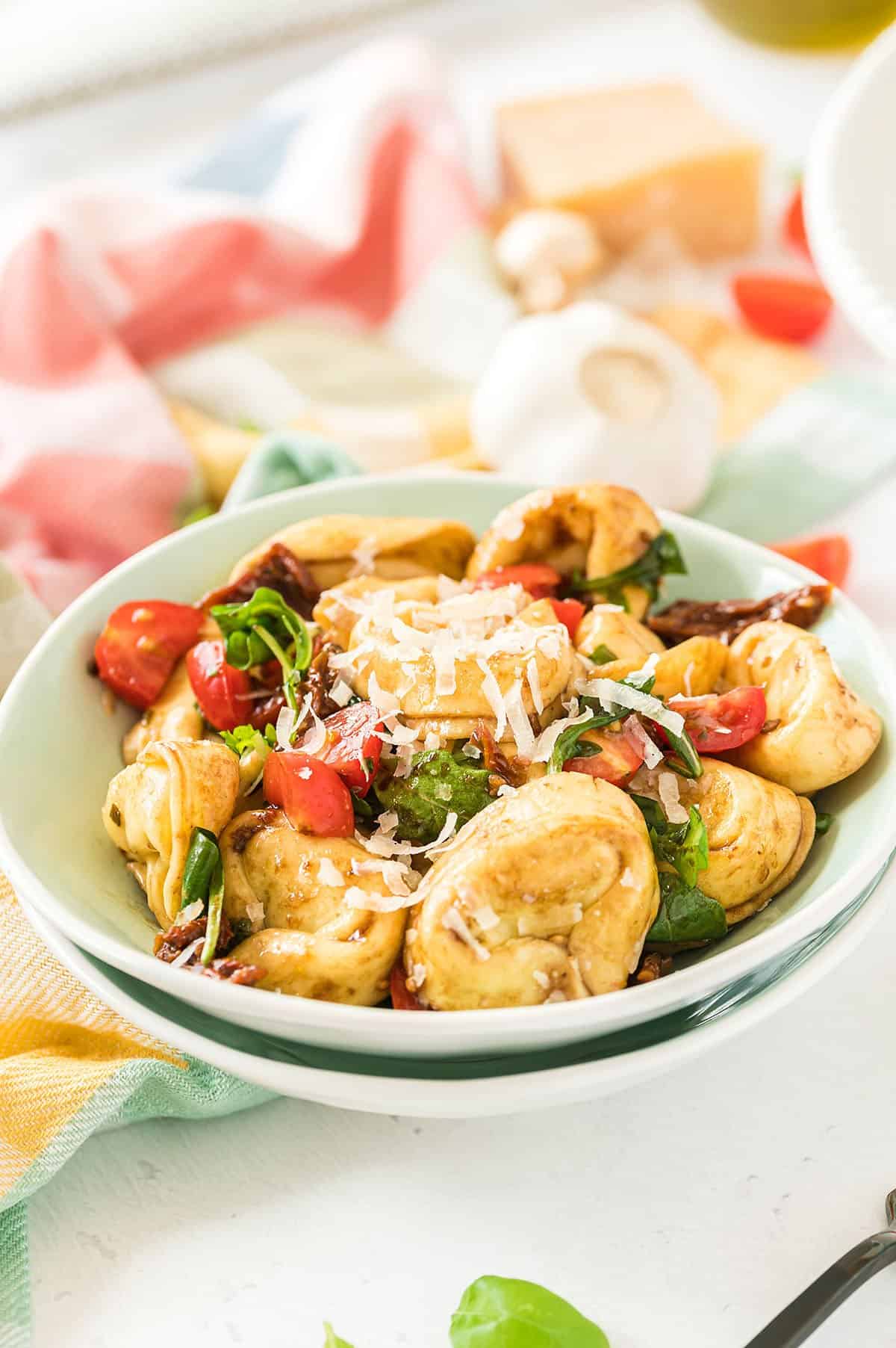 cold tortellini salad in small blue bowl.