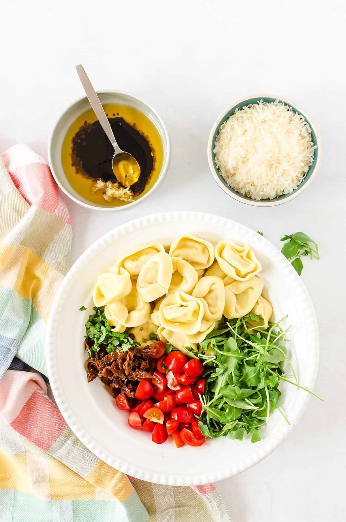 pasta salad ingredients in white bowl.