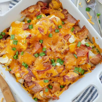 loaded cauliflower casserole in white baking dish.