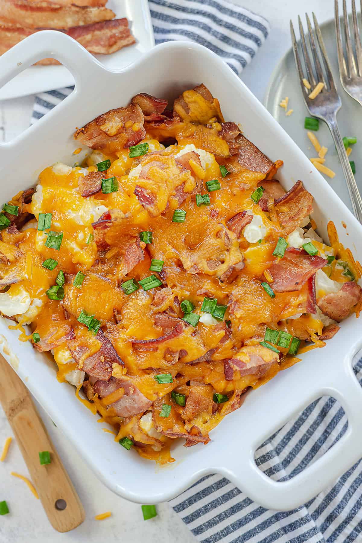 loaded cauliflower casserole in white baking dish.