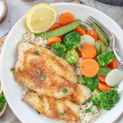 overhead view of air fryer tilapia in bowl with rice and veggies.