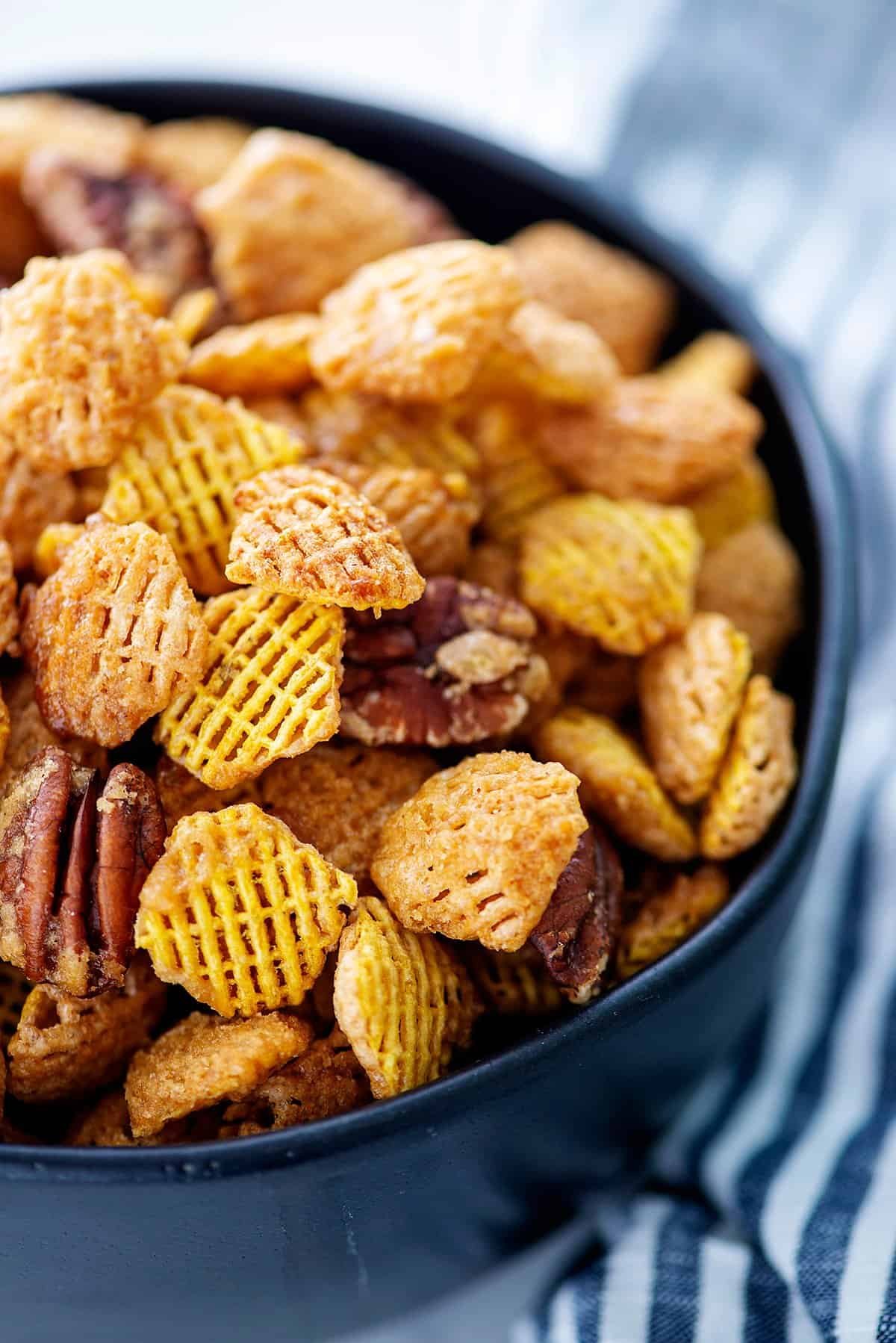 praline crunch snack mix in black bowl.