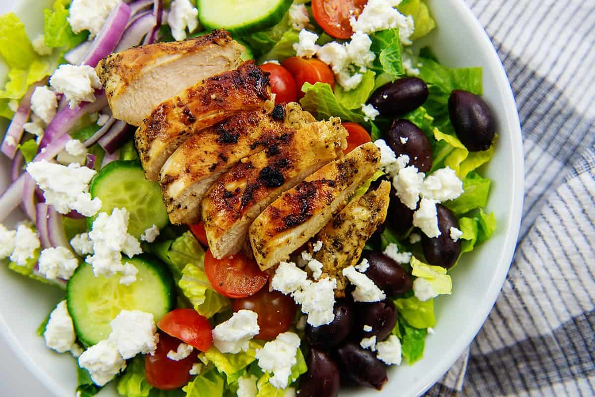 overhead view of greek salad in white bowl.