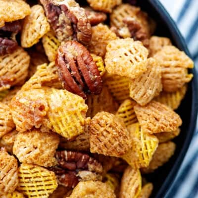 praline crunch snack mix in black bowl.