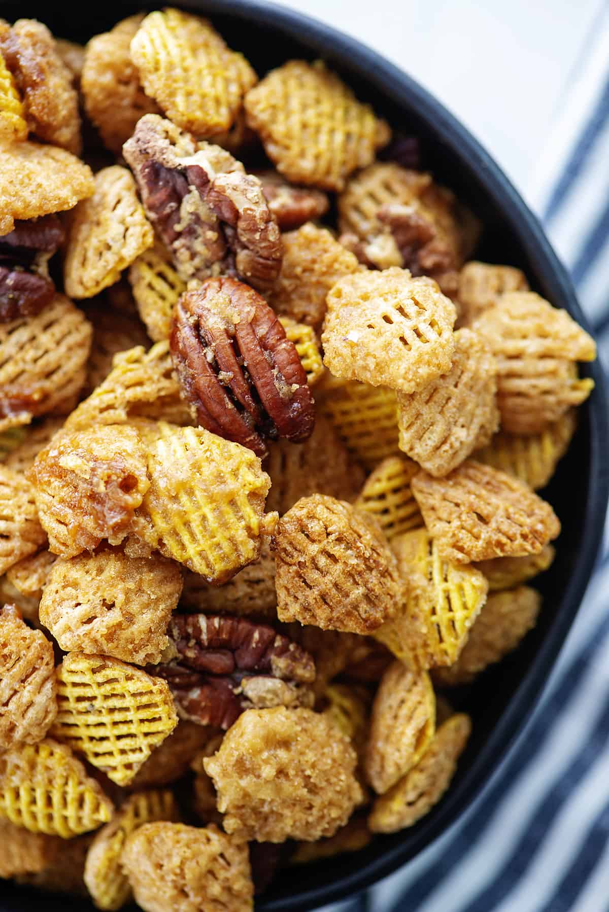 praline crunch snack mix in black bowl.