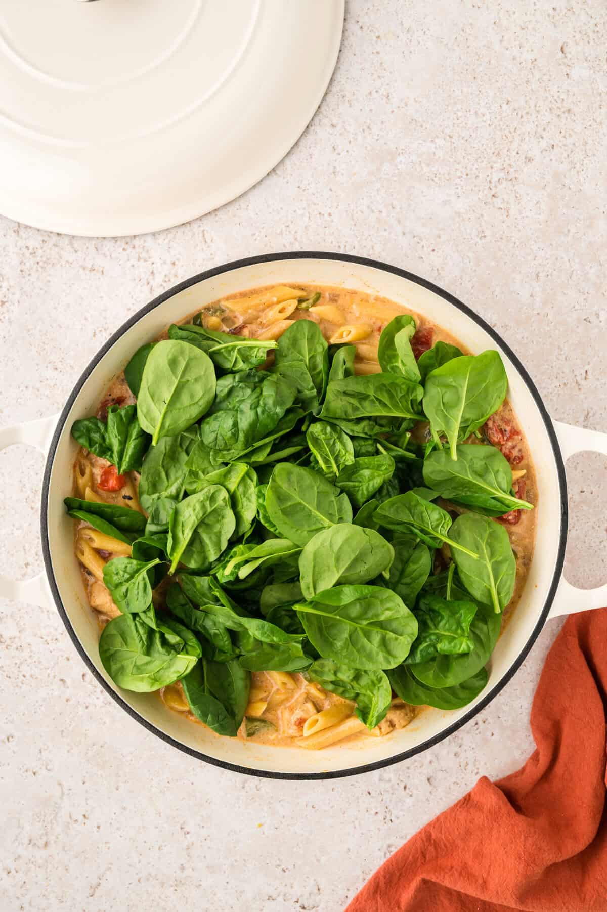 Fresh baby spinach added to pot of pasta.