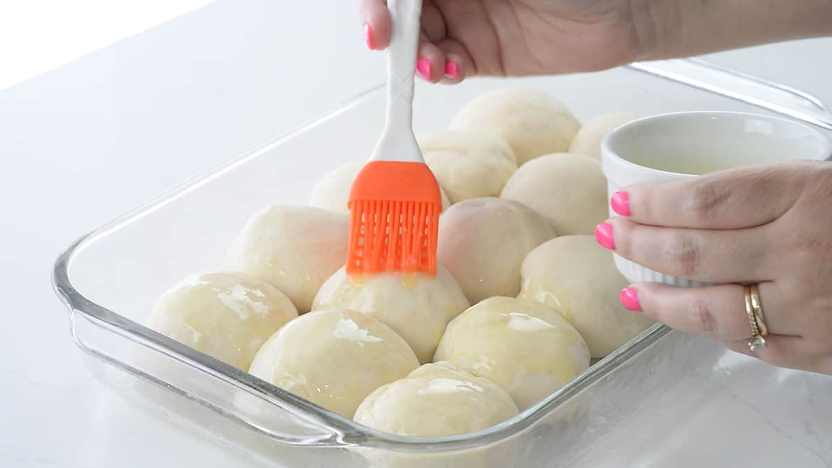 butter being brushed on rolls.