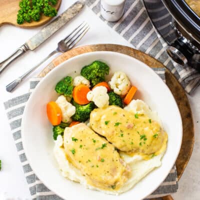 crockpot ranch pork chops on plate with veggies.