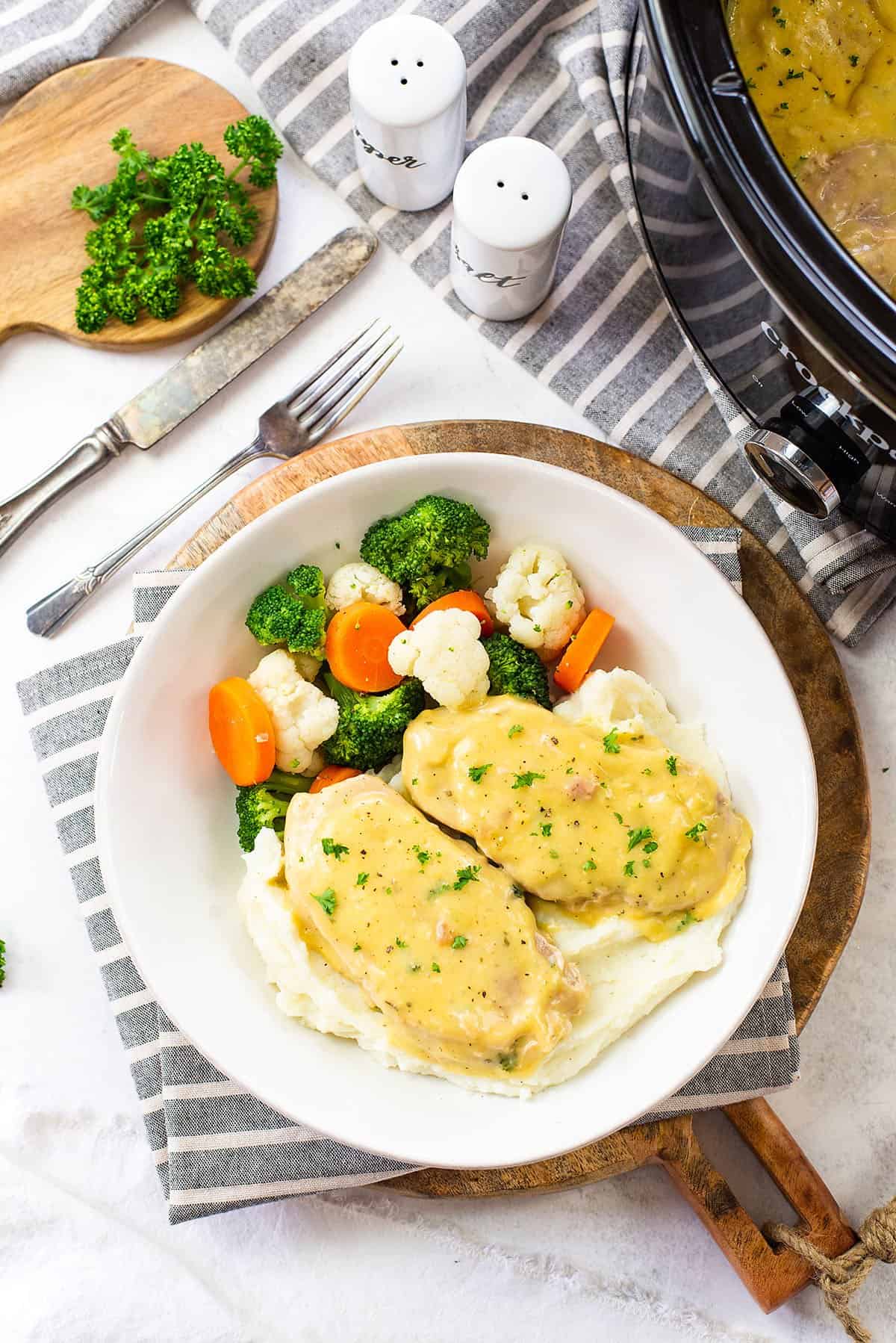 crockpot ranch pork chops on plate with veggies.