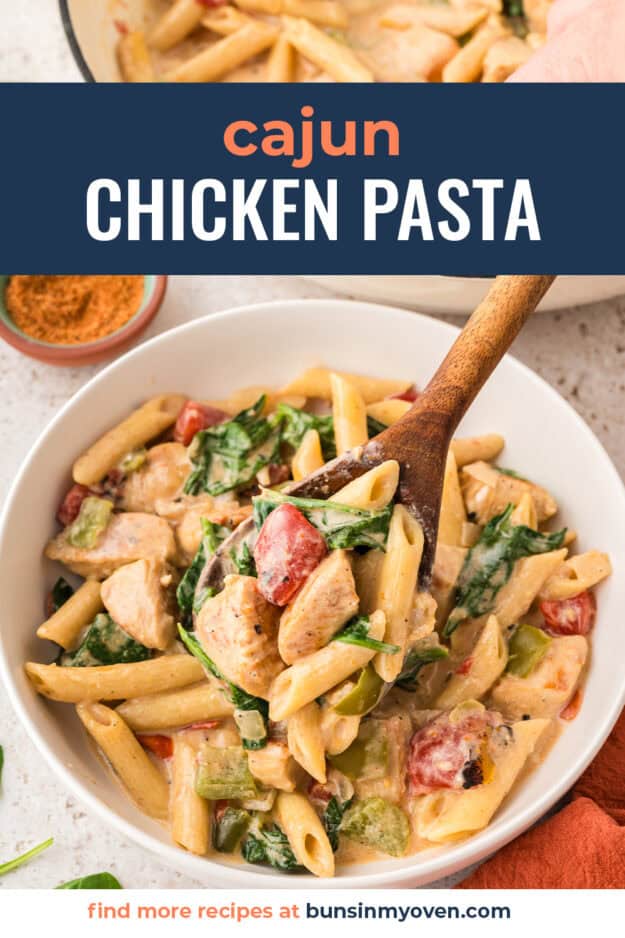Cajun chicken and spinach pasta recipe in bowl with wooden spoon.