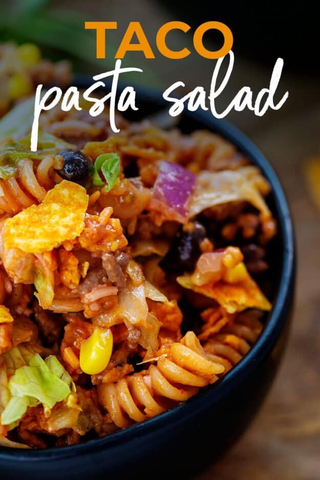 taco pasta salad in black bowl with text for Pinterest.