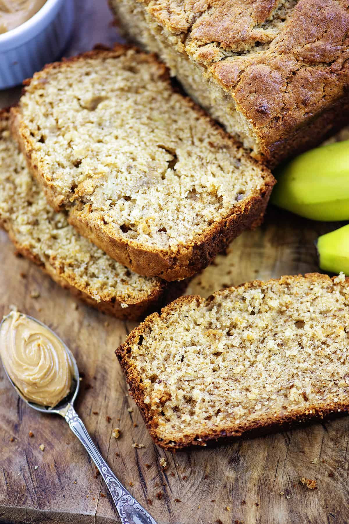 Sliced banana bread on wooden cutting board.