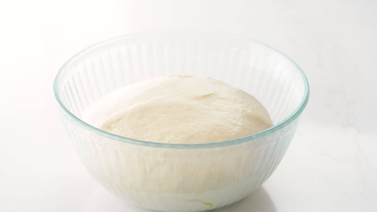 yeast dough in glass bowl.