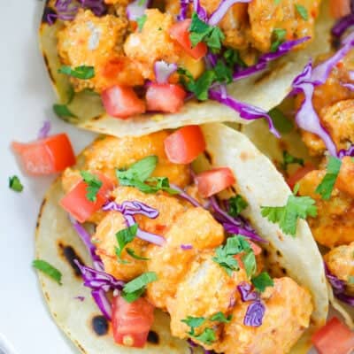 bang bang shrimp tacos on white plate.