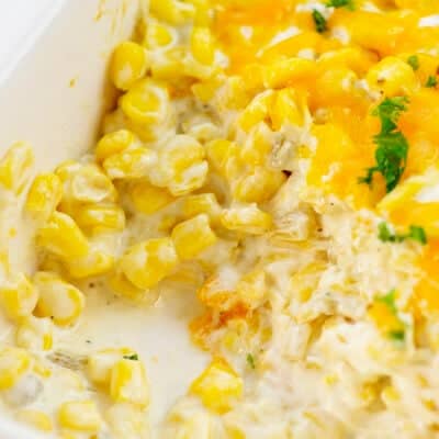 cream cheese corn casserole in white baking dish.