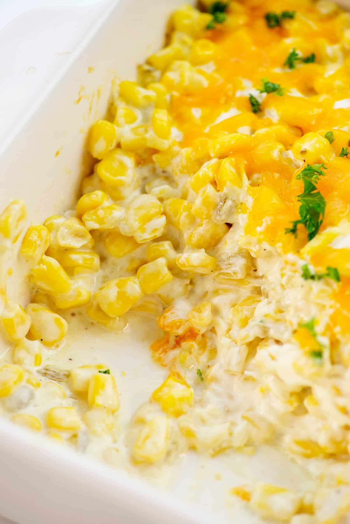 cream cheese corn casserole in white baking dish.