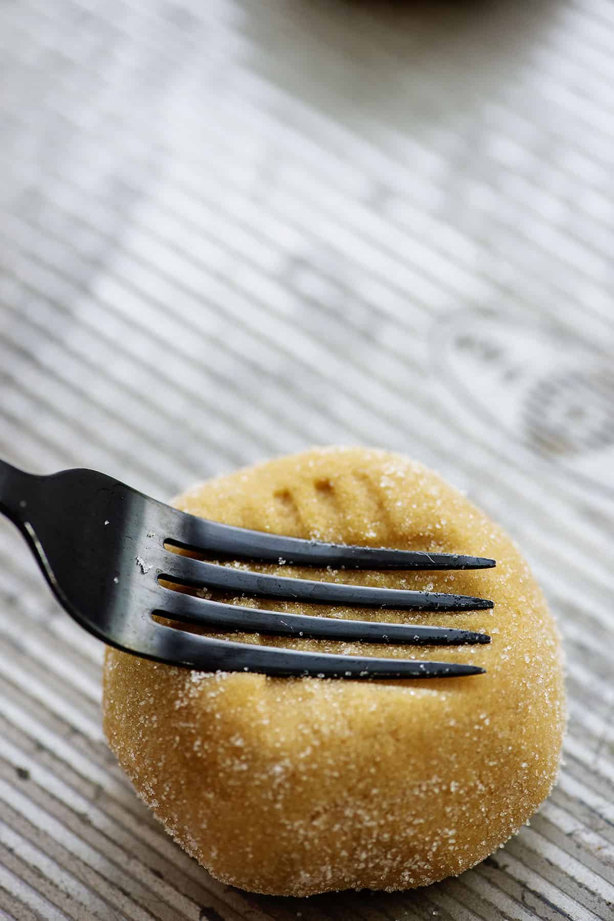 peanut butter cookies being pressed with fork.