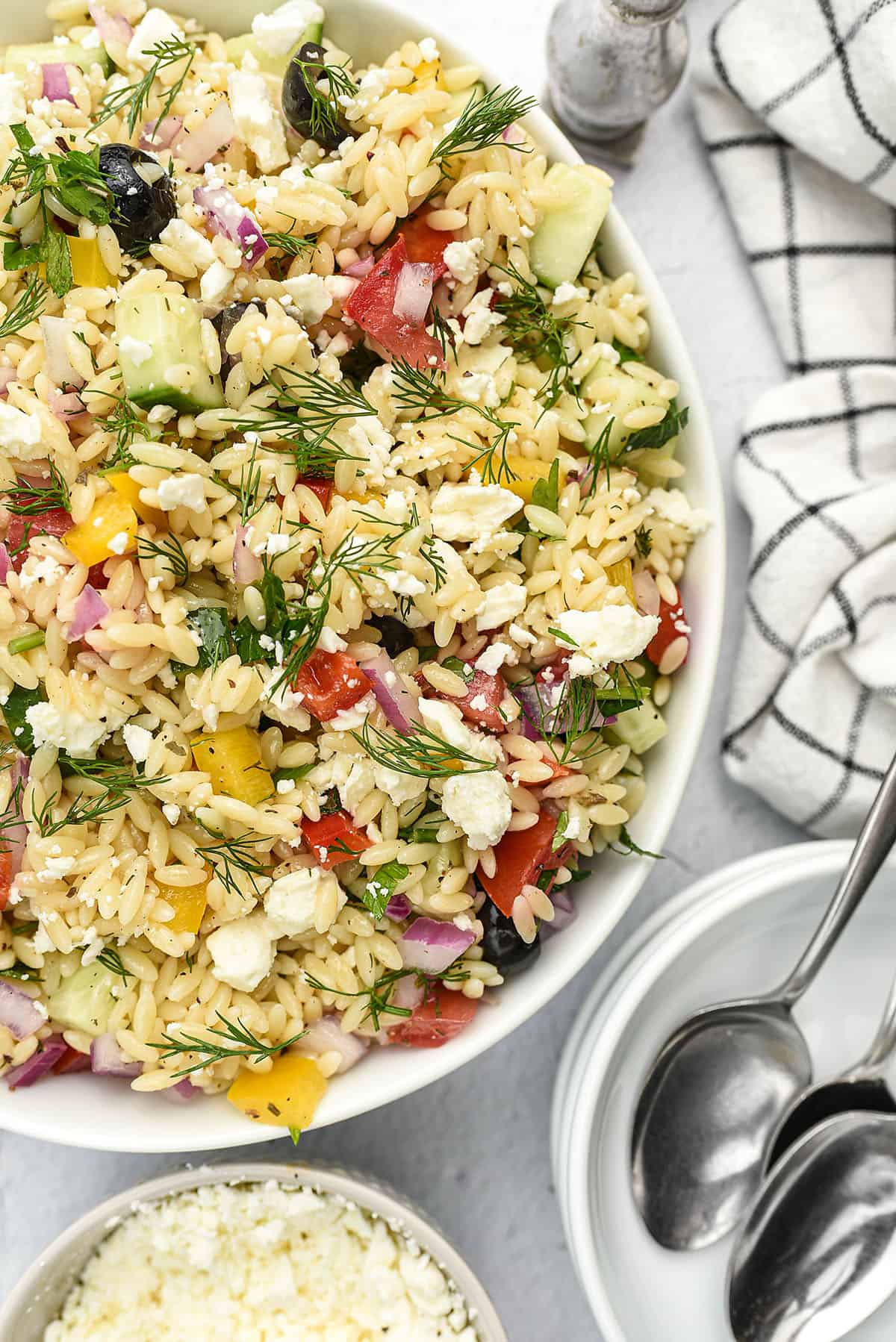 Greek orzo pasta salad in white bowl.