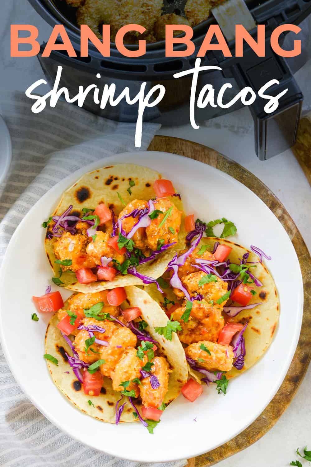 plate full of bang bang shrimp tacos with text for Pinterest.