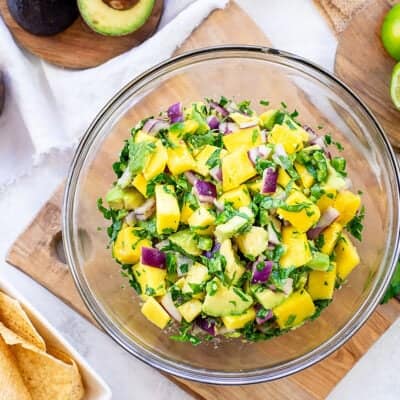 mango avocado salsa in bowl surounded by chips.