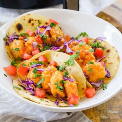 shrimp tacos on white plate.