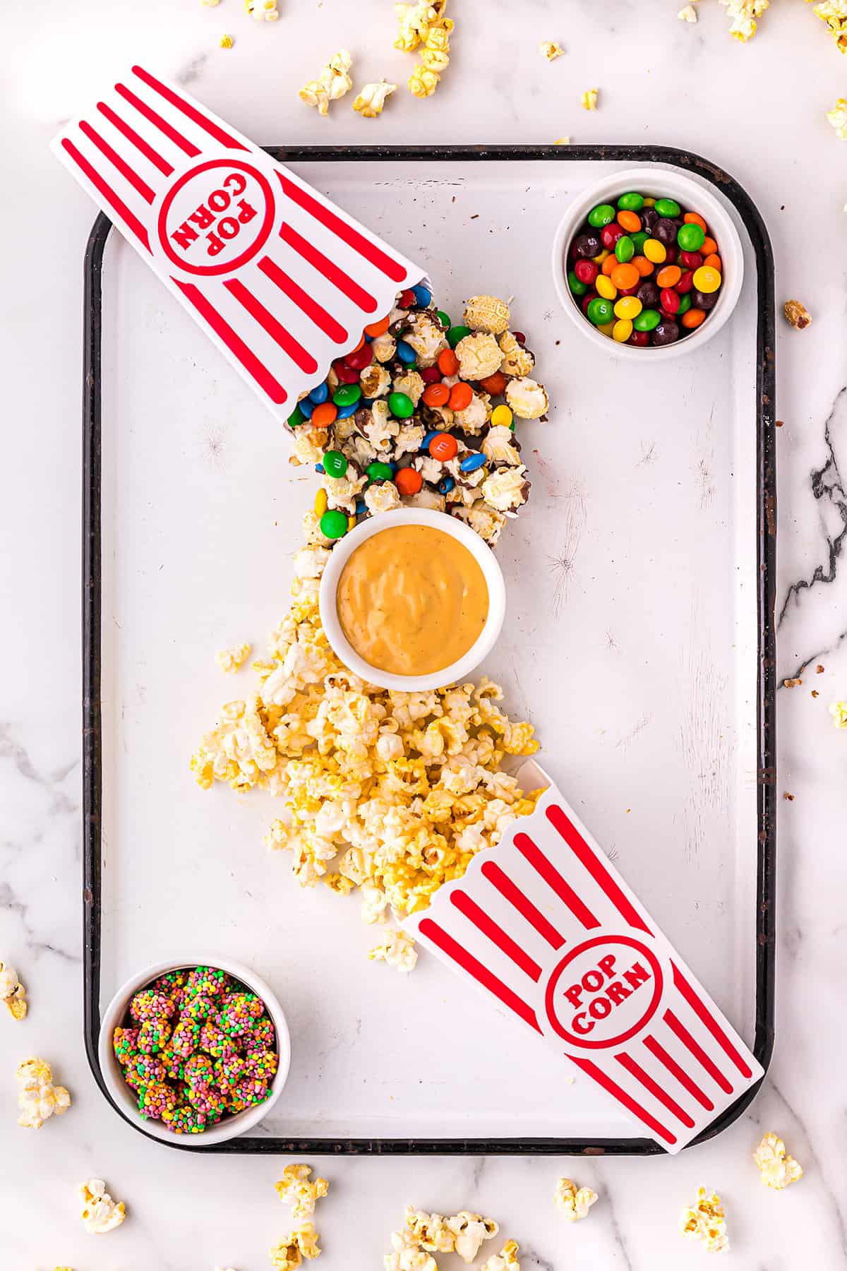 bowls and popcorn on snack board.