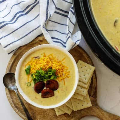 Overhead view of Cajun potato soup in bowl next to crockpot.
