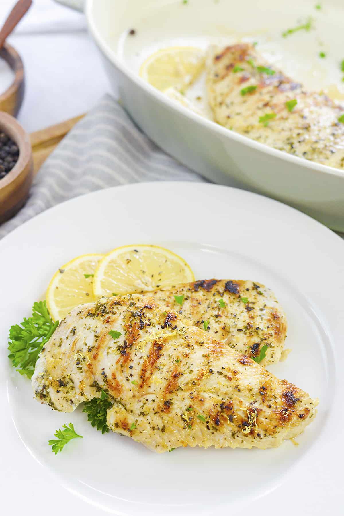 Lemon pepper grilled chicken on white plate.