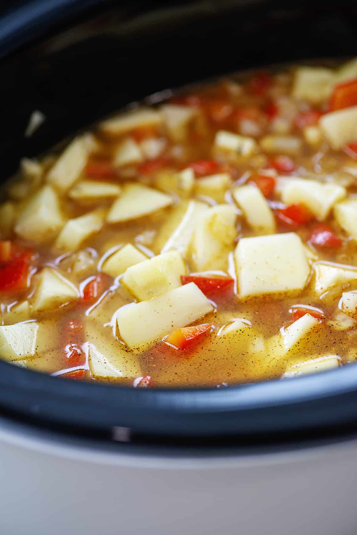 Potatoes and broth in crockpot.