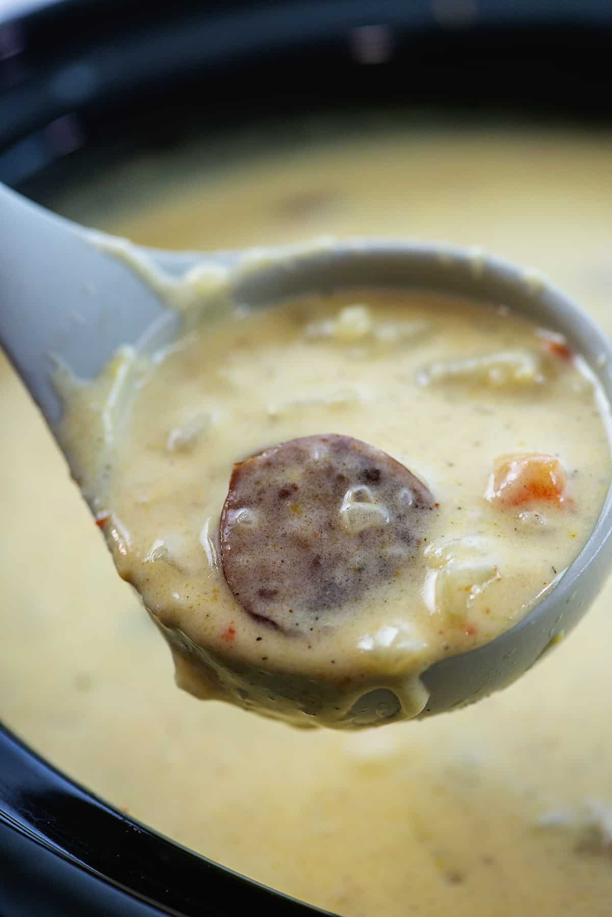 Cajun potato soup in ladle over crockpot.