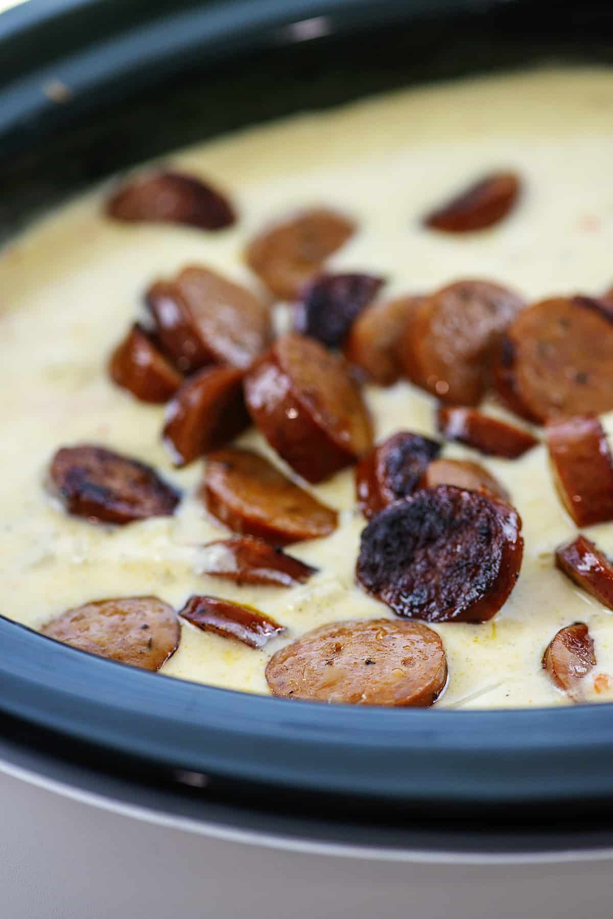 Sausage in potato soup in crockpt.