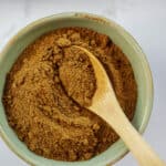 pumpkin pie spice in small green bowl on spoon.