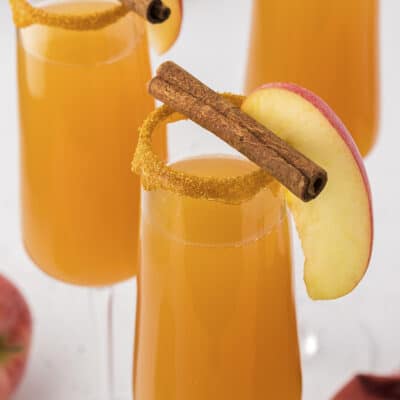 Apple Cider Mimosa in champagne flute with cinnamon stick.