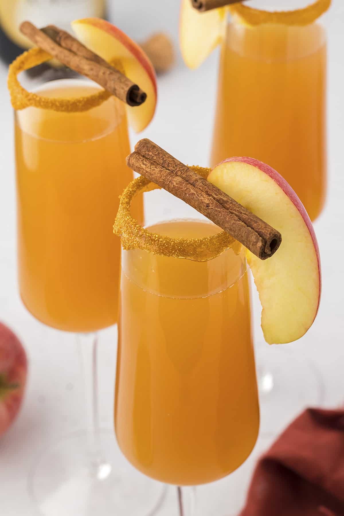 Apple Cider Mimosa in champagne flute with cinnamon stick.