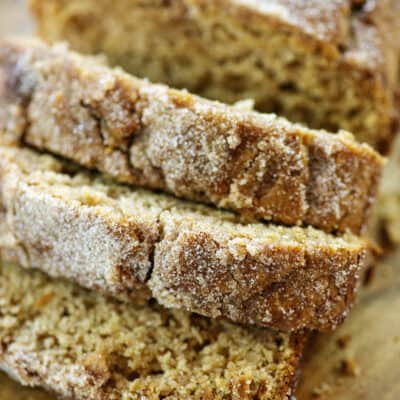 sliced loaf of apple cider donut bread on wooden cutting board.