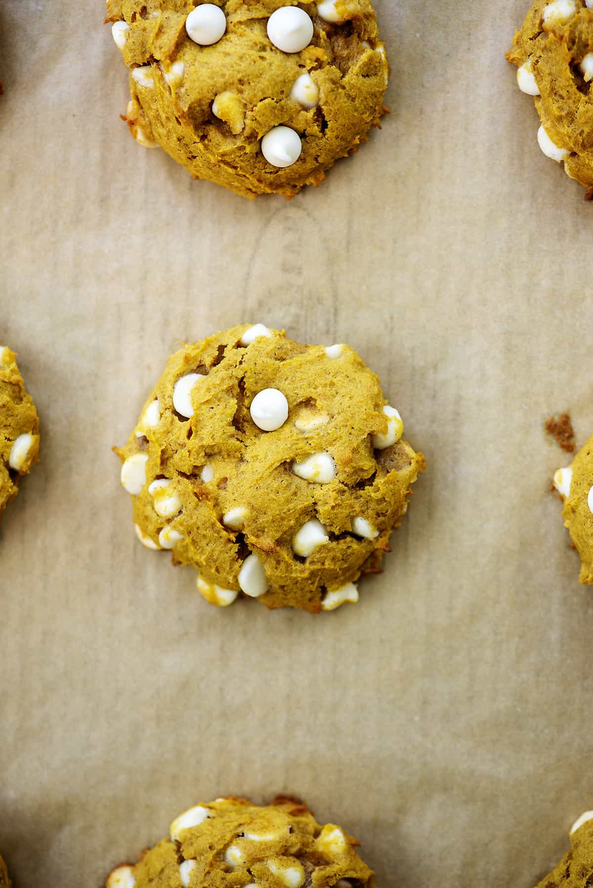 baked white chocolate chip pumpkin cookies on cookie sheet.