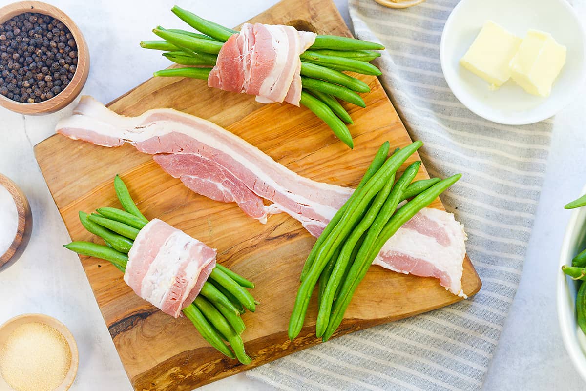 Green bean bundles being wrapped in bacon.