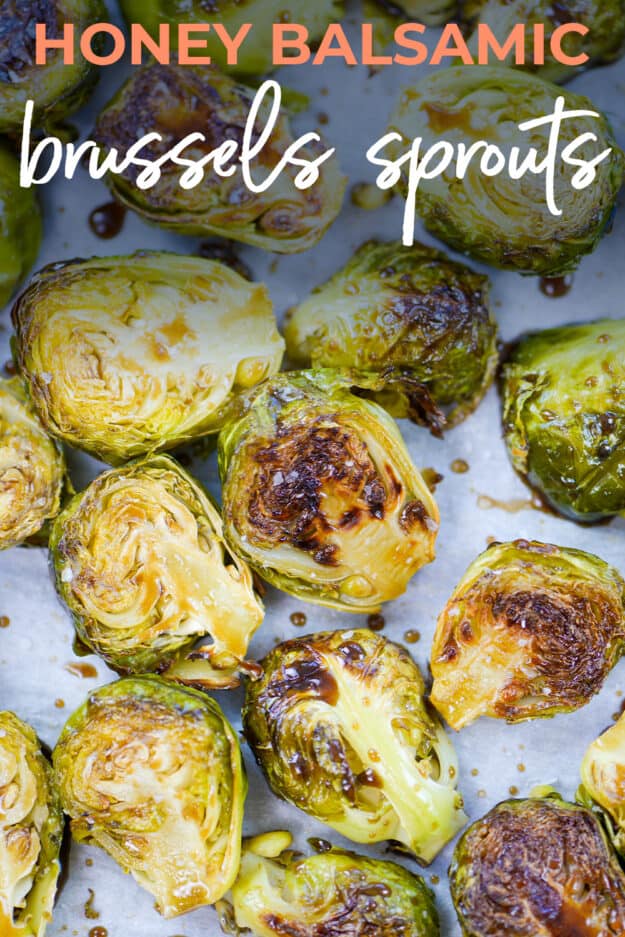 Roasted Brussels sprouts tossed in honey and balsamic vinegar on sheet pan.