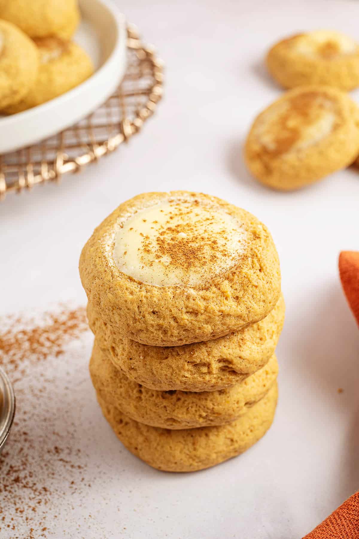stack of pumpkin cheesecake cookies on white counter.