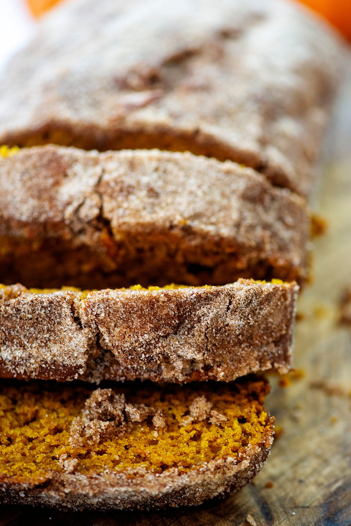 Cinnamon sugar pumpkin donut bread sliced on cutting board.