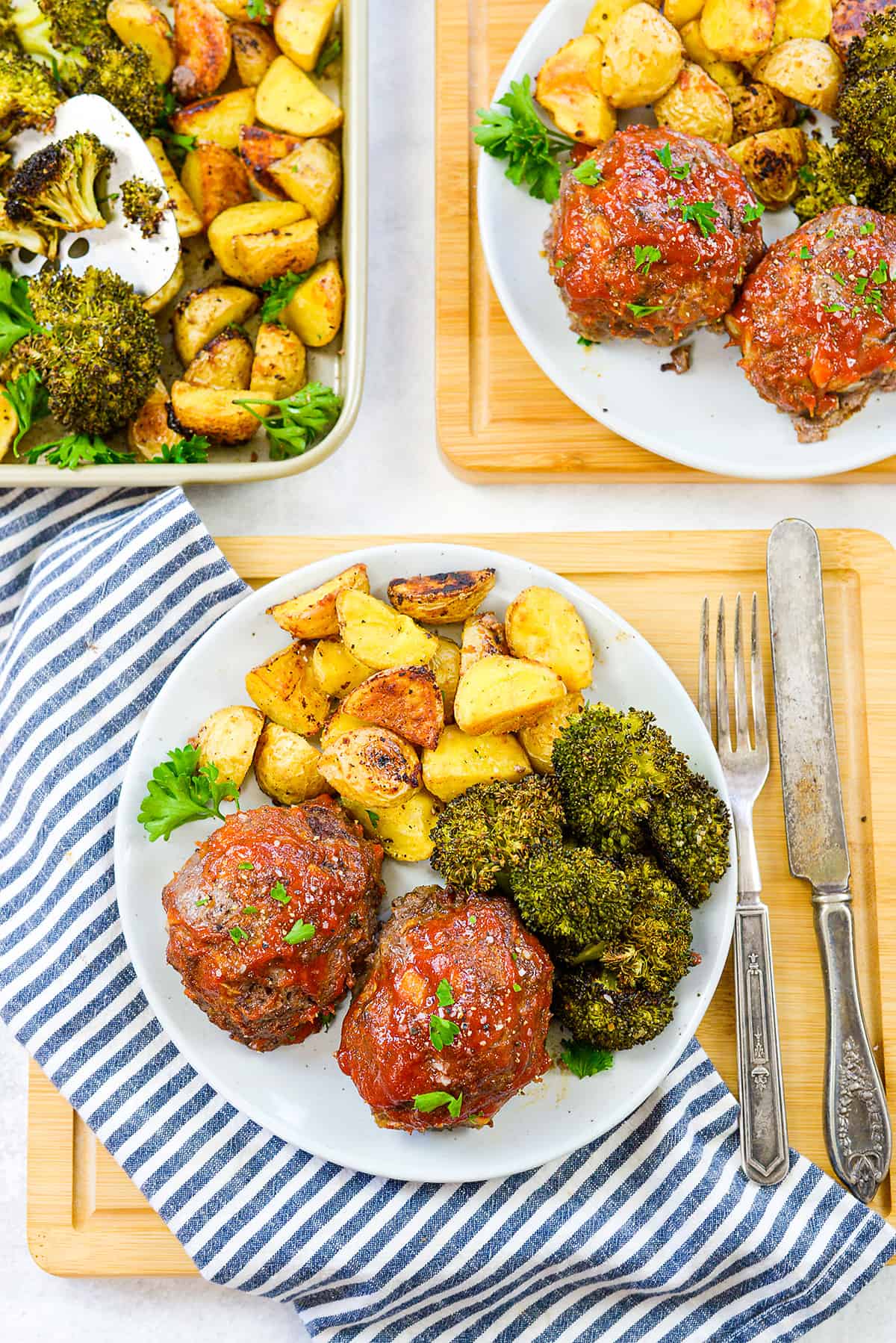 Mini meatloaves and veggies on white plate.