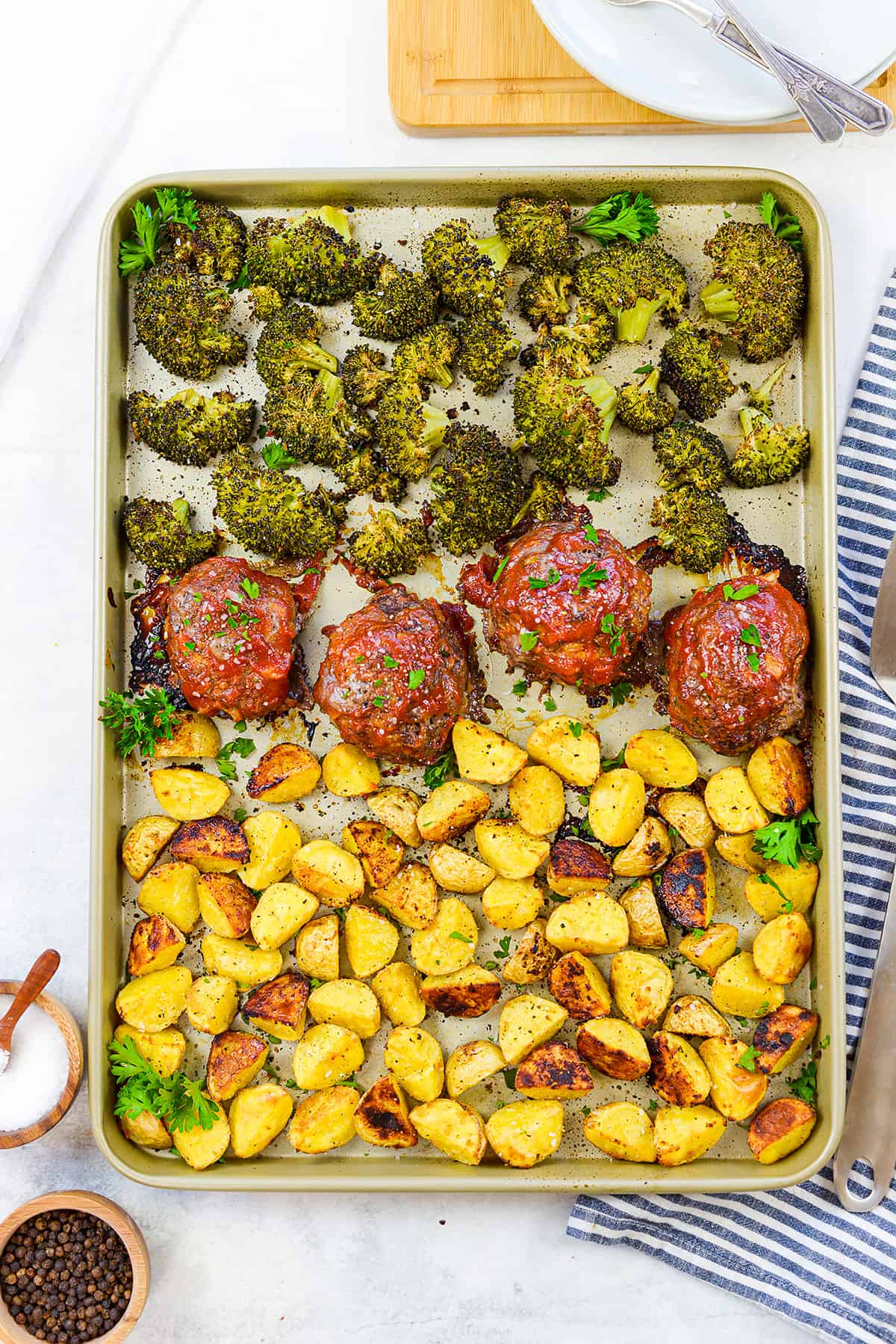 Overhead view of sheet pan meatloaf and veggies on pan.