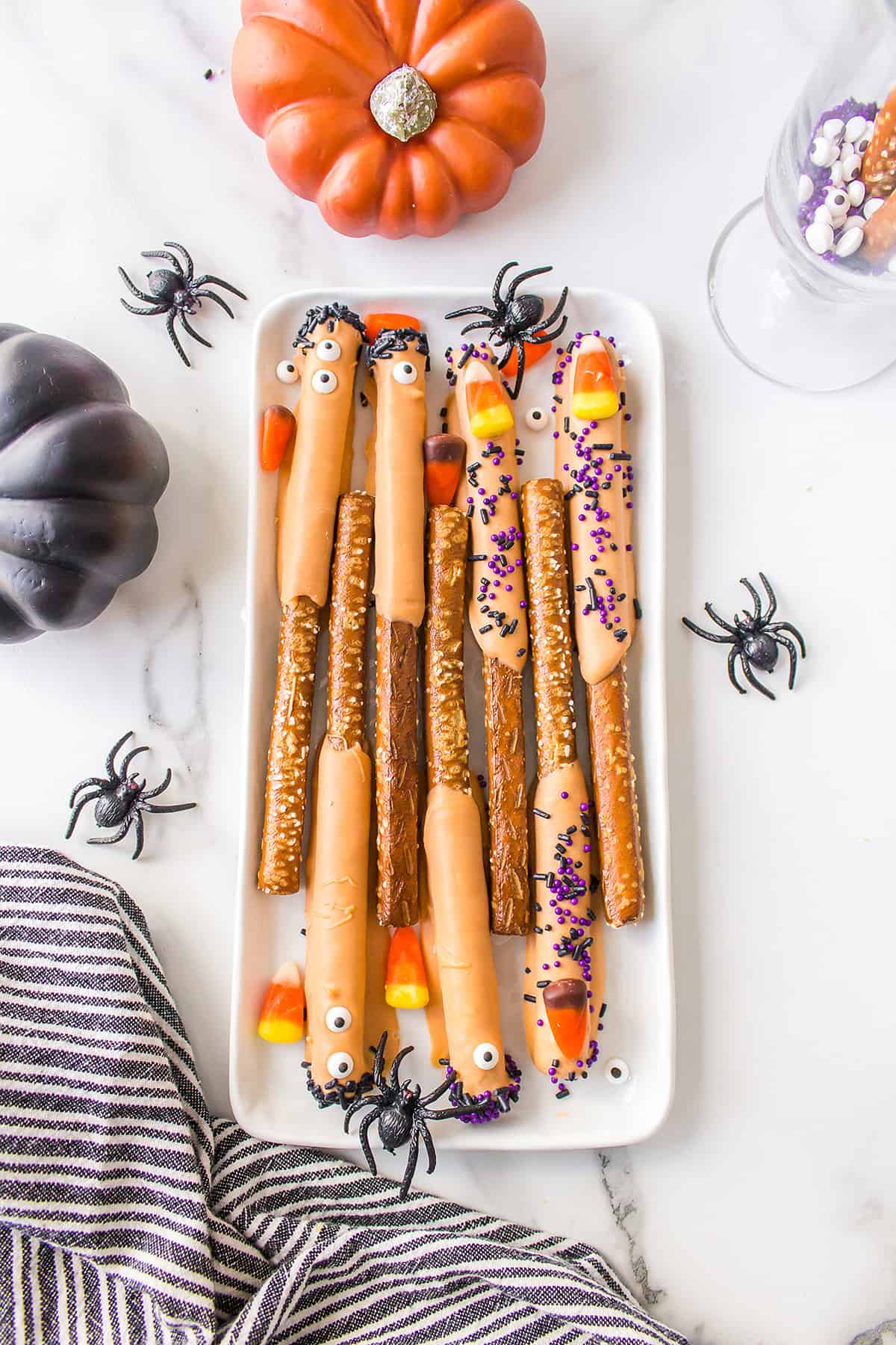 Halloween pretzel rods on white plate.