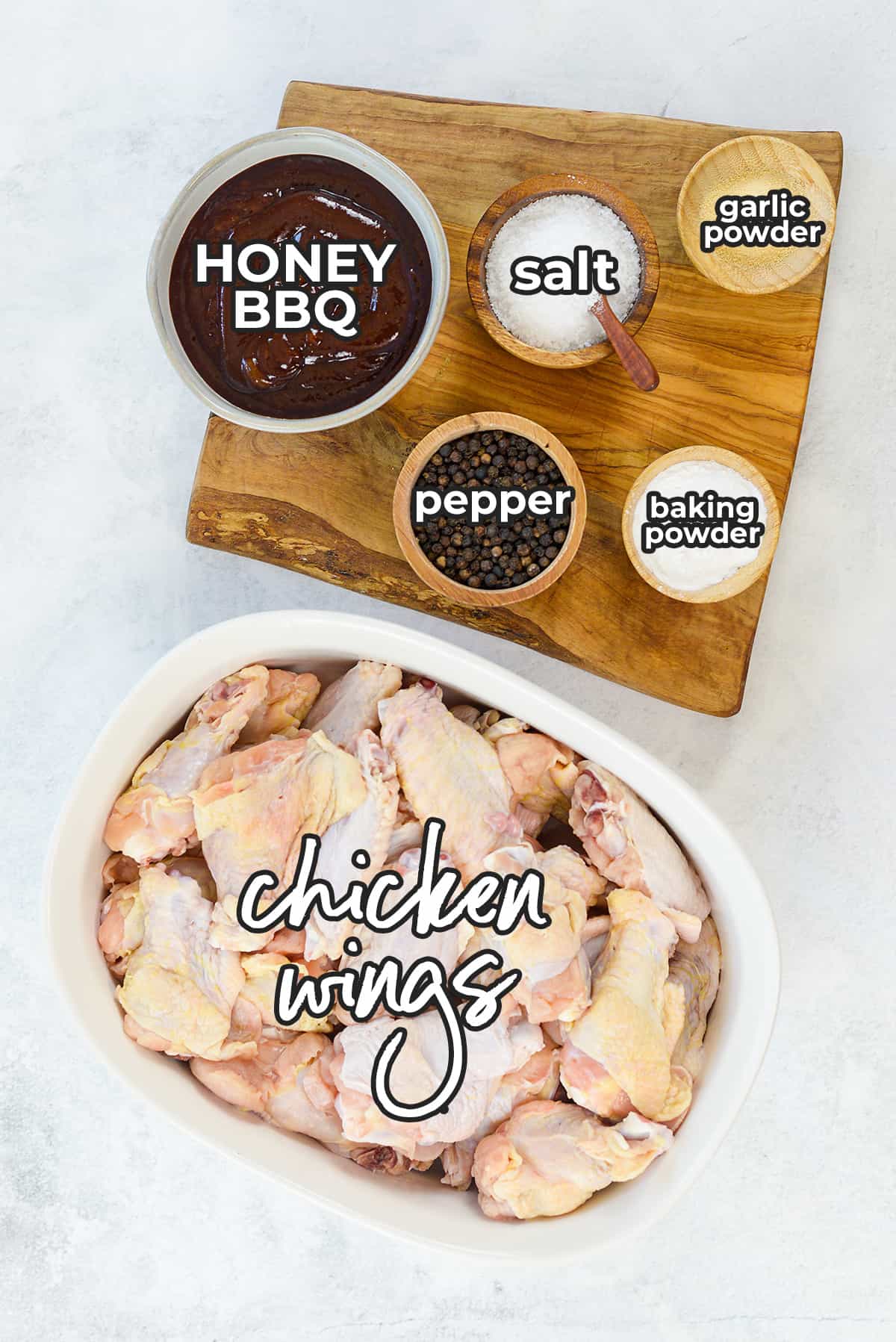 A top down view of all the ingredients used in this recipe including the seasoning, honey BBQ sauce, and raw chicken wings.