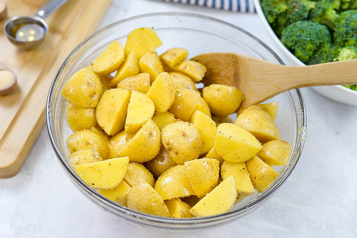 Seasoned potatoes in glass bowl.