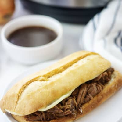 French dip sandwich on white plate.