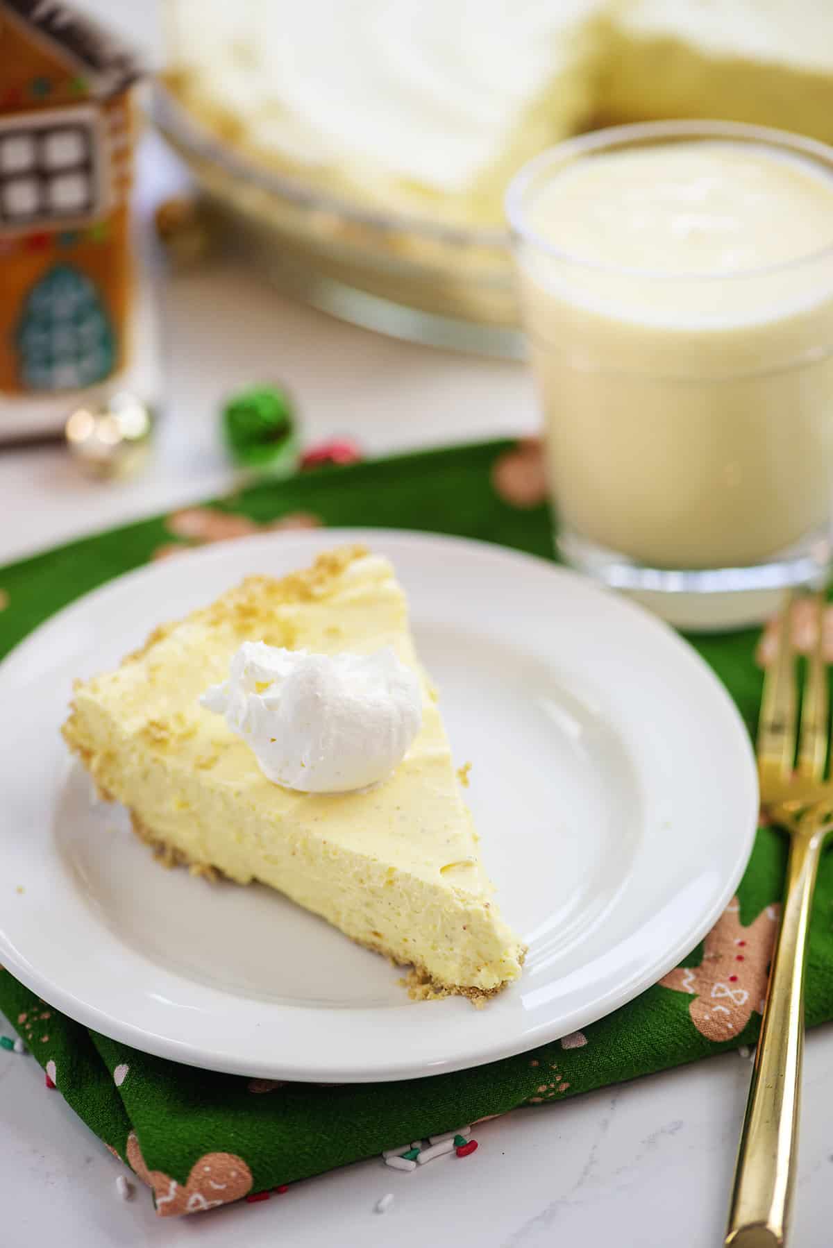 Slice of eggnog pie on white plate.