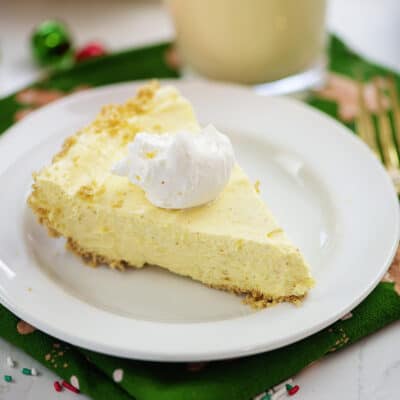 Eggnog pie on white plate with gold fork.