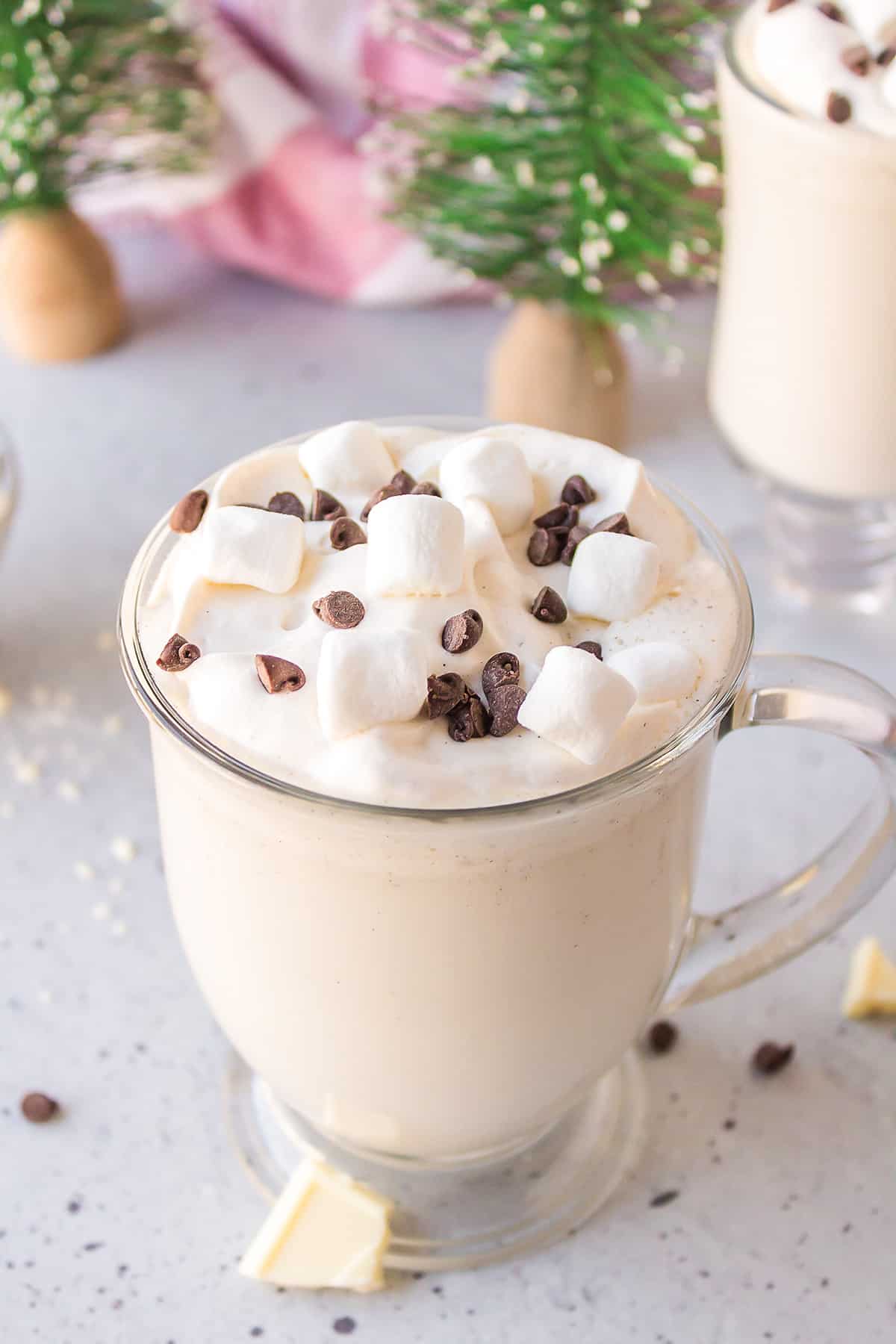 Creamy white hot chocolate in glass mug.