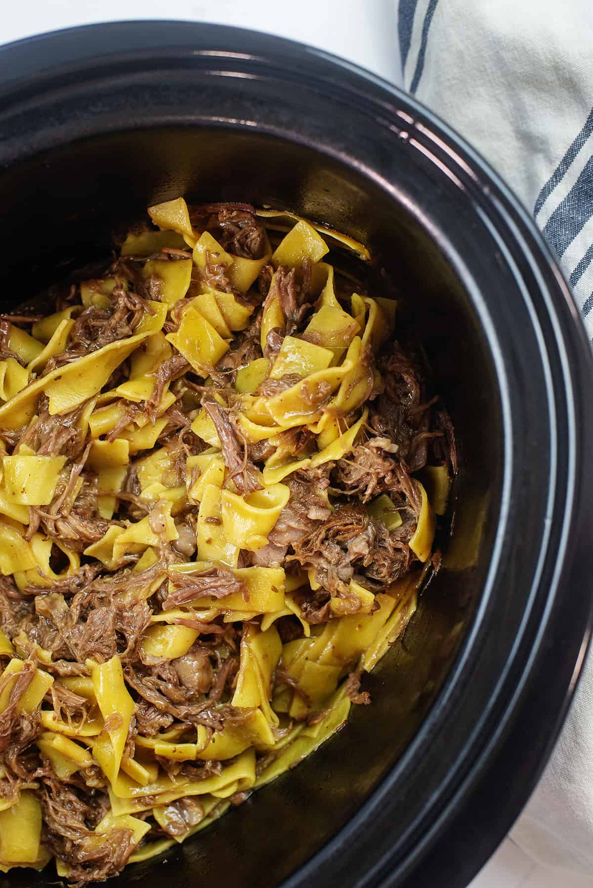 Overhead view of Mississippi beef and noodles in crockpot.